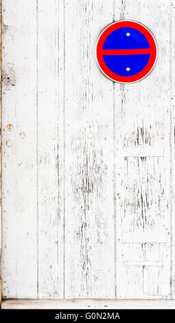 Keine Parkplätze-Sing an einer Garage verwitterte weiße Holztür mit weißer Farbe gesäumt und peeling. Stockfoto