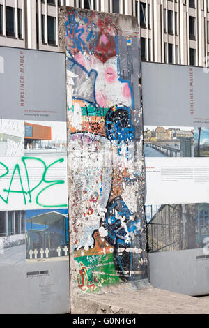 Teil der Berliner Mauer am Potsdamer Platz 2016 mit Touristen und ein Mann verkleidet als Soldat der ehemaligen DDR Stockfoto