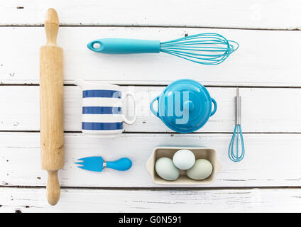 Blaue Küchenhelfer auf einem rustikalen Holztisch weiß Stockfoto