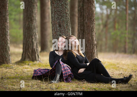 Niedlichen Mädchen Freunde sitzen in den Wald. Stockfoto