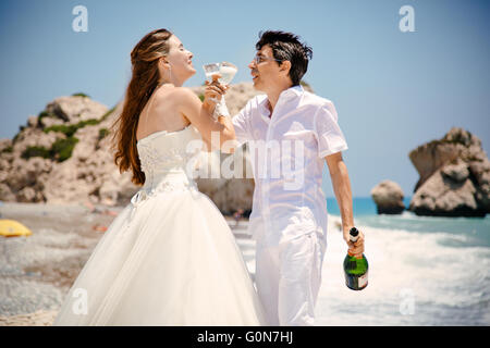 Braut und Bräutigam mit Gläsern Champagner am Strand Mittelmeer Stockfoto