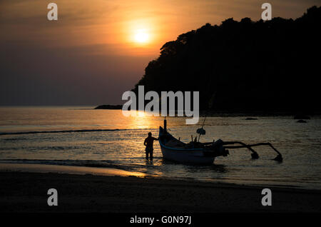Ein Fischer in Agonda, Goa, Indien ist immer bereit, in einem goldenen Sonnenuntergang für einen nächtlichen Fischzug zu verlassen Stockfoto