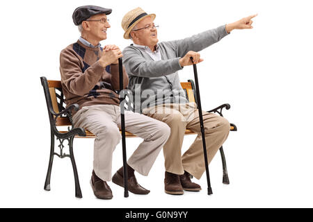 Fröhlichen senior Gentleman zeigt etwas zu einem alten Freund sitzen auf einer Bank, die isoliert auf weißem Hintergrund Stockfoto