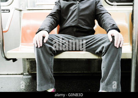 Mann in Beschlag nehmen mehr als einen Sitz (man-Verteilung) auf New Yorker U-Bahn (tube), NYC, USA Stockfoto