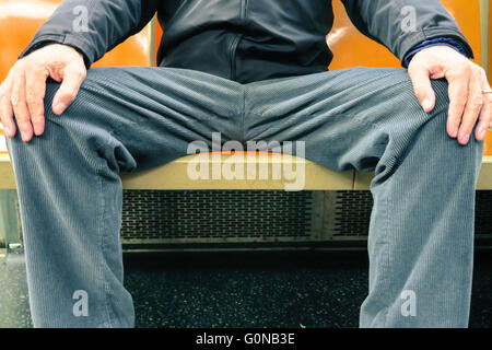 Mann in Beschlag nehmen mehr als einen Sitz (man-Verteilung) auf New Yorker U-Bahn (tube), NYC, USA Stockfoto