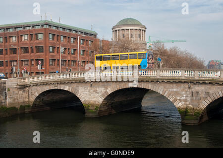 Irland, Stadt von Dublin, gelben Tourbus auf Vater Mathew Brücke über den Fluss Liffey, Four Courts im Hintergrund, Stadtbild, s Stockfoto