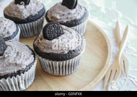 Hausgemachte dunkle Schokolade Cupcakes mit Cookie und Creme Zuckerguss Stockfoto