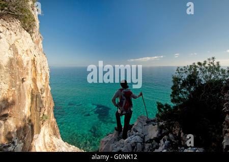 Baunei, Sardinien, Italien, 12/2015. Frau, die das Meer entlang der berühmten Selvaggio Blu-trekking-Route in der Ogliastra-Küste zu beobachten. Stockfoto