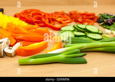 Schuss von einigen frisch gehackte Salat Zwiebeln und Paprika, umgeben von anderen zubereitetes Gemüse hautnah Stockfoto