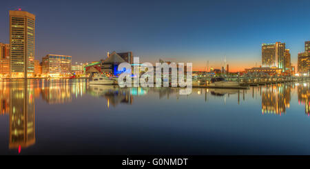 Teil der Skyline von Baltimore, Maryland spiegelt sich in den Gewässern des Flusses Patapsco im Innenhafen vor Sonnenaufgang Stockfoto