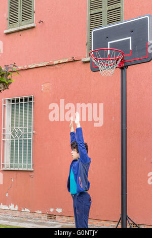 junge Training defensiven Positionen in einen Basketballplatz Grunge in der Nähe von der Peeling-Wand eines alten Hauses Stockfoto