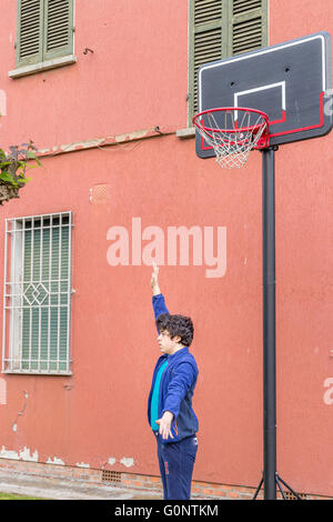 junge Training defensiven Positionen in einen Basketballplatz Grunge in der Nähe von der Peeling-Wand eines alten Hauses Stockfoto