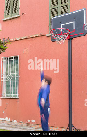 junge Training defensiven Positionen in einen Basketballplatz Grunge in der Nähe von der Peeling-Wand eines alten Hauses Stockfoto