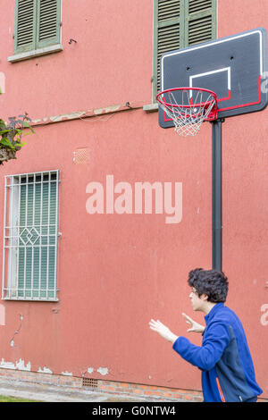 junge Training defensiven Positionen in einen Basketballplatz Grunge in der Nähe von der Peeling-Wand eines alten Hauses Stockfoto