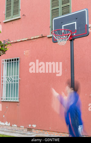 junge Training defensiven Positionen in einen Basketballplatz Grunge in der Nähe von der Peeling-Wand eines alten Hauses Stockfoto