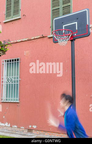 junge Training defensiven Positionen in einen Basketballplatz Grunge in der Nähe von der Peeling-Wand eines alten Hauses Stockfoto