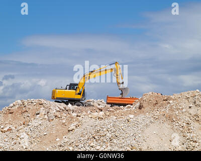 Bagger laden Kipper auf Baustelle Stockfoto