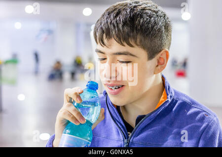Porträt des kaukasischen jungen gehen, während im Wartezimmer am Bahnhof zu trinken Stockfoto