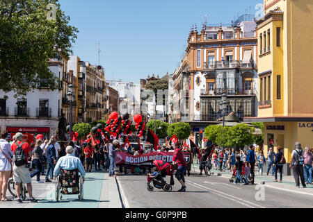 Menschen, darunter auch Menschen im Rollstuhl & Frau schieben Kinderwagen, sehen Sie Arbeiter mit Luftballons und Fahnen, Mayday Protest zu sammeln. Stockfoto