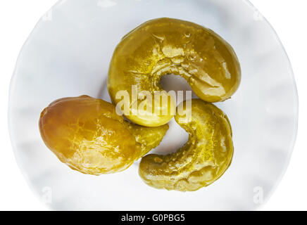 Drei gebogene Gurken auf den weißen Teller Stockfoto