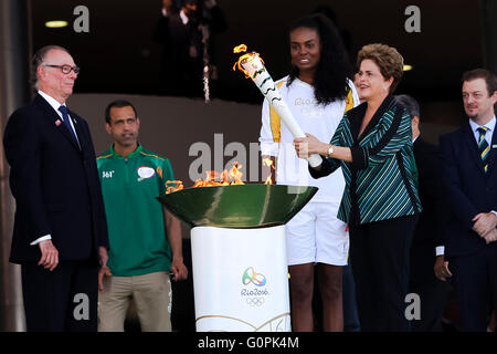 Brasilianische Präsidentin Dilma Rousseff leuchtet die Olympische Flamme als brasilianischer Beachvolleyballspieler sieht auf Fabiana Claudino während der Zeremonie am Präsidentenpalast Planalto 3. Mai 2016 in Brasilia, Brasilien. Der Fackellauf beginnt eine dreimonatige Reise durch Brasilien, vor der Ankunft für die Olympischen Spiele in Rio De Janeiro im August. Stockfoto