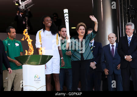 Brasilianische Präsidentin Dilma Rousseff leuchtet die Olympische Flamme als brasilianischer Beachvolleyballspieler sieht auf Fabiana Claudino während der Zeremonie am Präsidentenpalast Planalto 3. Mai 2016 in Brasilia, Brasilien. Der Fackellauf beginnt eine dreimonatige Reise durch Brasilien, vor der Ankunft für die Olympischen Spiele in Rio De Janeiro im August. Stockfoto