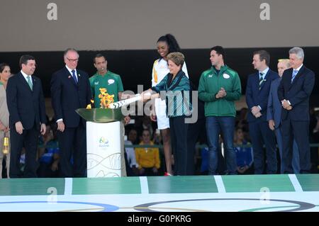 Brasilianische Präsidentin Dilma Rousseff leuchtet die Olympische Flamme als brasilianischer Beachvolleyballspieler sieht auf Fabiana Claudino während der Zeremonie am Präsidentenpalast Planalto 3. Mai 2016 in Brasilia, Brasilien. Der Fackellauf beginnt eine dreimonatige Reise durch Brasilien, vor der Ankunft für die Olympischen Spiele in Rio De Janeiro im August. Stockfoto