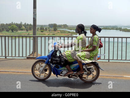 Bamako, Mali. 2. Mai 2016. Zwei Frauen fahren ein Moped über eine Brücke über den Fluss Niger in Bamako, Mali, 2. Mai 2016. Foto: Britta Pedersen/Dpa/Alamy Live News Stockfoto