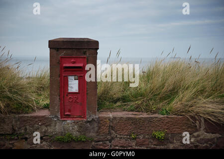 Eine traditionelle alte rote König George Briefkasten am Strand in North Berwick, Schottland. Stockfoto