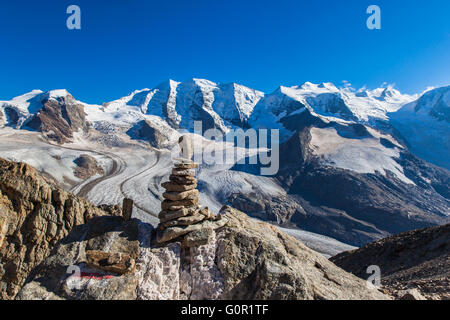 Atemberaubende Aussicht Stein Haufen an der Spitze der Munt Pers mit der Bernina Massiv darunter Piz Palu und Morteratsch-Gletscher in der bac Stockfoto