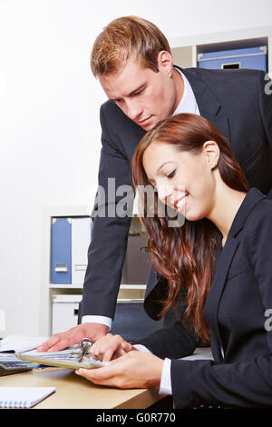 Geschäftsmann, Blick auf Tablet-PC von einer Frau im Büro Stockfoto
