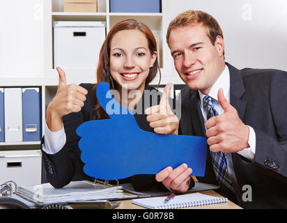 Zwei glückliche Geschäftsleute viele Daumen hochhalten im Büro Stockfoto