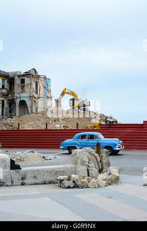 Amerikanische Oldtimer geht ein Abriss-Baustelle, wo ein altes Gebäude von einem Bulldozer in Havanna, Kuba zerstört wird Stockfoto