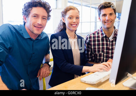 Geschäftsleute, Lächeln und posieren vor einem computer Stockfoto