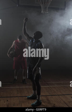 Seine Arme hob siegreich Basketballspieler Stockfoto