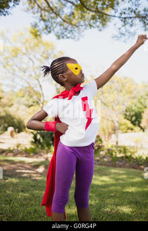 Ein kleines Mädchen, die vorgibt, fliegen mit Superhelden-Kostüm Stockfoto