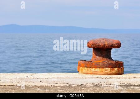 Alten, rostigen Festmacher Poller am Hafen von Podgora, Kroatien. Platz auf der linken Seite. Stockfoto