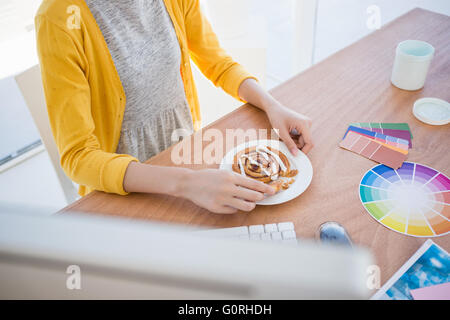 Frau bei der Arbeit zu frühstücken Stockfoto