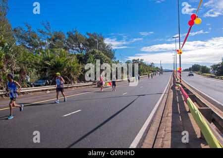 Viele unbekannte Teilnehmer konkurrieren in der Deloitte Herausforderung Marathon auf der M4-Autobahn in Durban, Südafrika Stockfoto