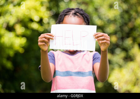 Junge hält ein Plakat mit Hilfe Stockfoto