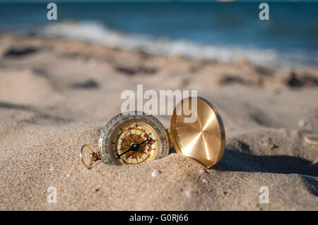 vergoldete Kompass auf dem Sand am Strand liegen Stockfoto