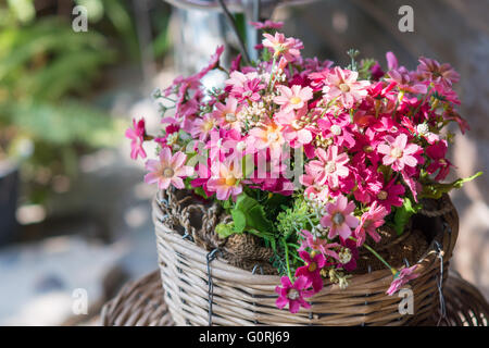 Bunte Blumen in einem Korb auf einem weichen Hintergrund verschwimmen. Stockfoto