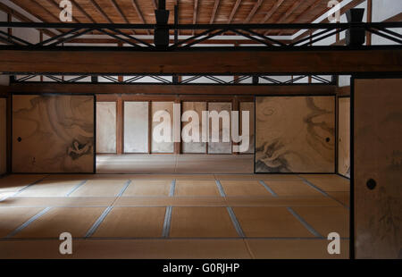 Eine Innenansicht mit natürlichen Licht zeigt die Tatami-Matte Zimmer mit handgemalten Fusuma Schiebetüren und natürliche Holzdecke in der Haupthalle Kuri an Ryōan-Ji, ein Zen-buddhistischen Tempel und UNESCO-Welterbe im nördlichen Bereich von Kyoto, Japan. Stockfoto