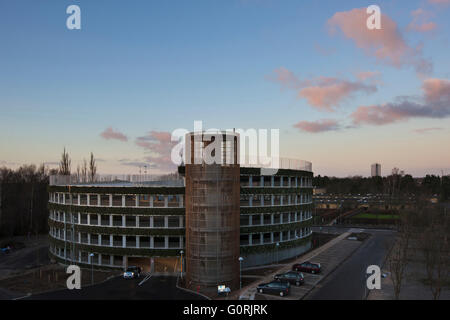 Parkplatz-Anlage, Glostrup Hospital, Copenhagen. Das Runde Gebäude hinterlässt einen minimalen Platzbedarf und Sonnenkollektoren entlang der Fassade mit der grünen Wand bietet einen üppigen visuellen Eindruck eingearbeitet hat. Blick auf das äußere des Krankenhauses. Stockfoto