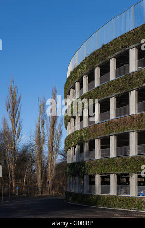 Parkplatz-Anlage, Glostrup Hospital, Copenhagen. Das Runde Gebäude hinterlässt einen minimalen Platzbedarf und Sonnenkollektoren entlang der Fassade mit der grünen Wand bietet einen üppigen visuellen Eindruck eingearbeitet hat. Außenansicht der Parkanlage mit Laub Stockfoto