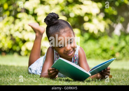 Kleines Mädchen ein Buch im park Stockfoto