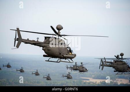 Zweiunddreißig OH - 58D Kiowa Warrior Hubschrauber mit der 17. Kavallerie-Regiment, 82. Combat Aviation Brigade, fliegen in Formation während einer Überführung Abschied 15. April 2016 in Fort Bragg, North Carolina. Die Flugzeuge werden abgeschafft, da ihre Funktion durch remote gesteuerten unbemannte Drohnen ersetzt wurde. Stockfoto