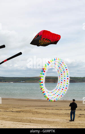 Mann mit ringförmigem Drachen mit farbigen Stacheln beim Weymouth Kite Festival, Dorset UK im Mai Stockfoto