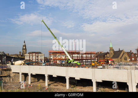 Bau In Arbeit auf den neuen Bolton Busbahnhof mit einem mobilen Kran heben Abschnitte von Stahlkonstruktionen in Platz. Stockfoto