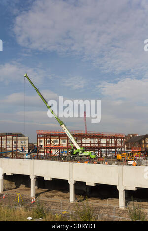 Bau In Arbeit auf den neuen Bolton Busbahnhof mit einem mobilen Kran heben Abschnitte von Stahlkonstruktionen in Platz. Stockfoto